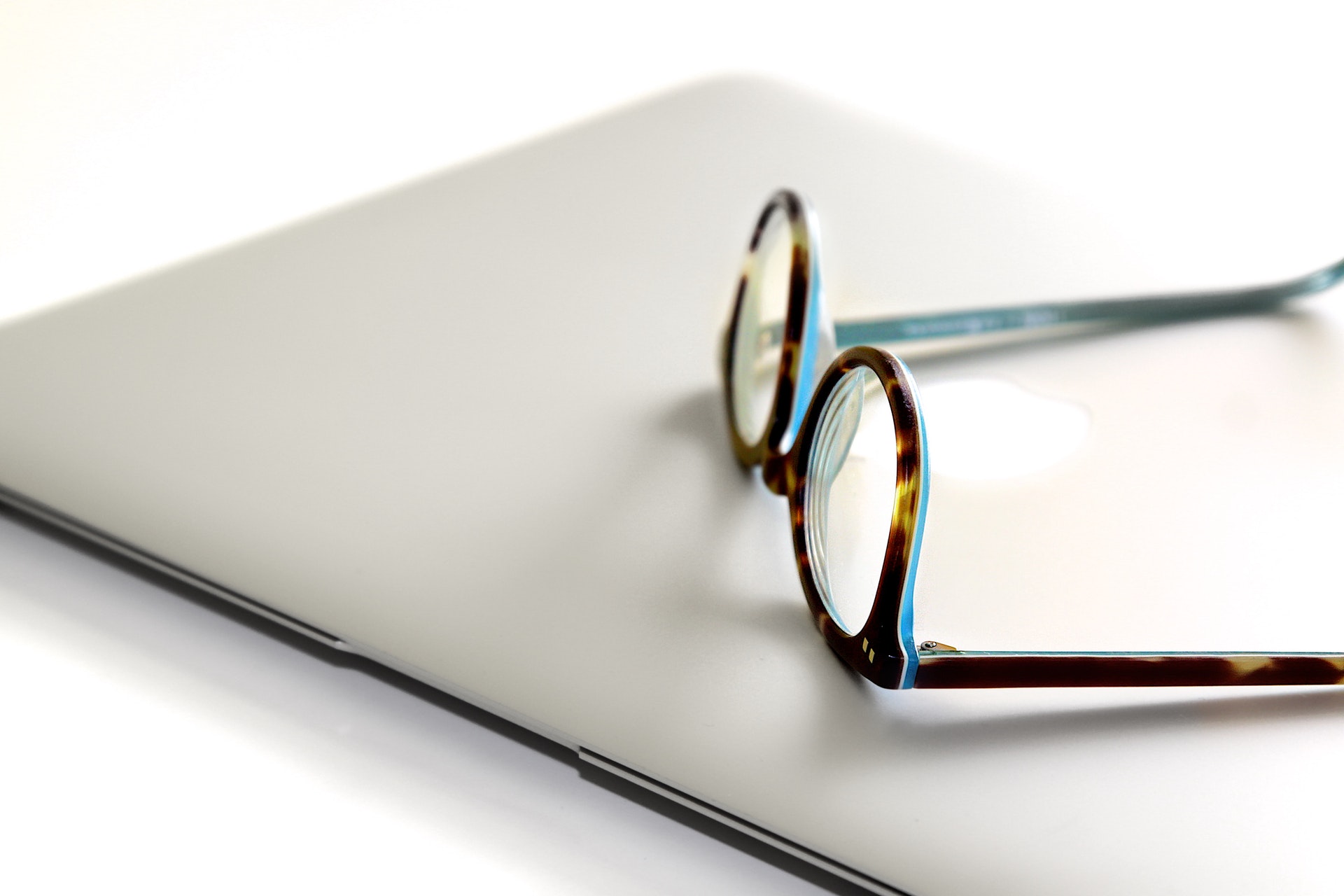 This is an image of a pair of glasses on top of an Apple laptop.