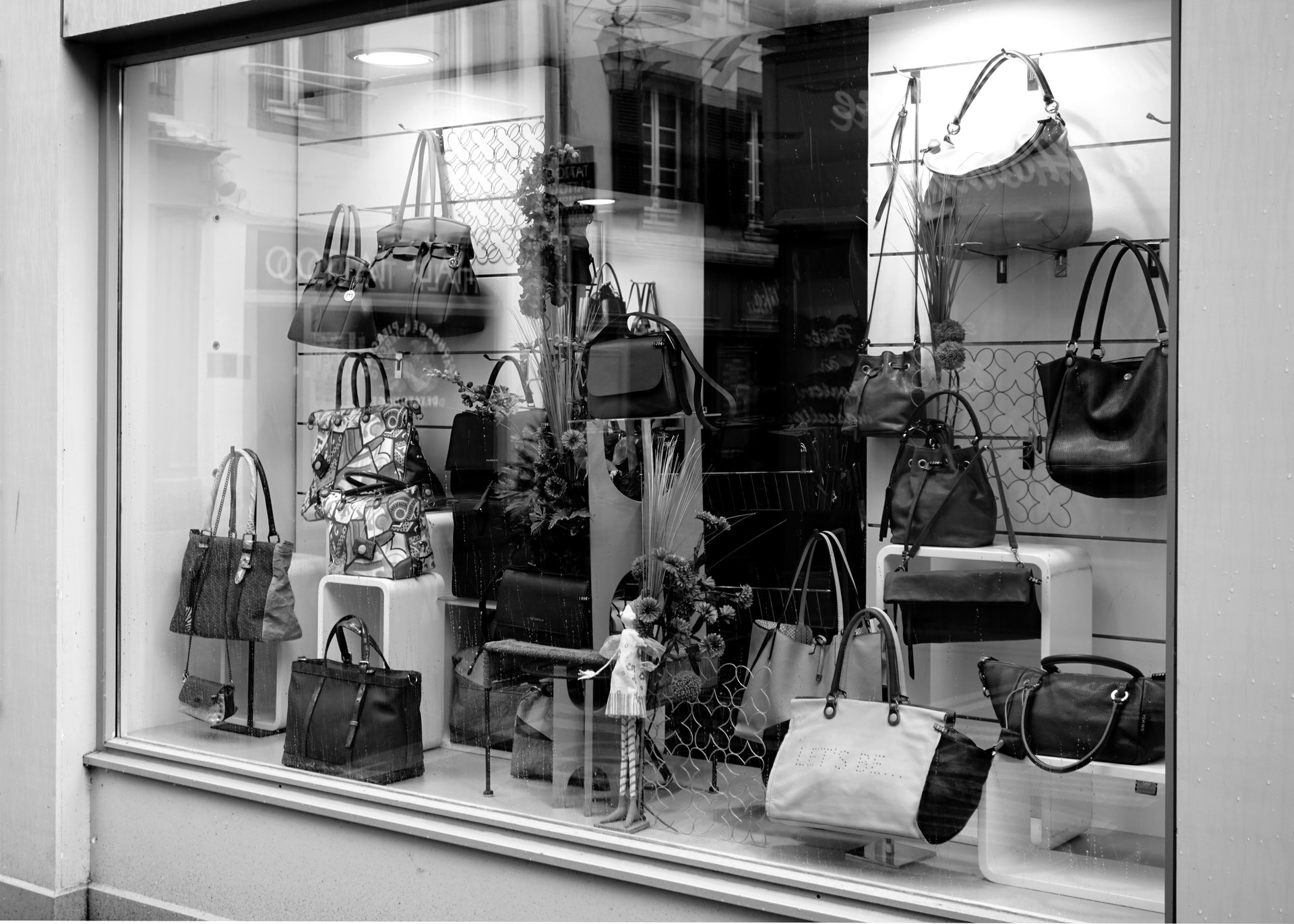 purses handing in the window of a retail store