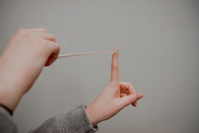 Person holding a rubber band.