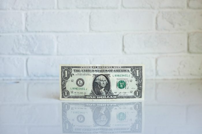 dollar bill in front of brick wall