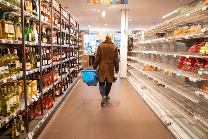 Woman walking down grocery store aisle