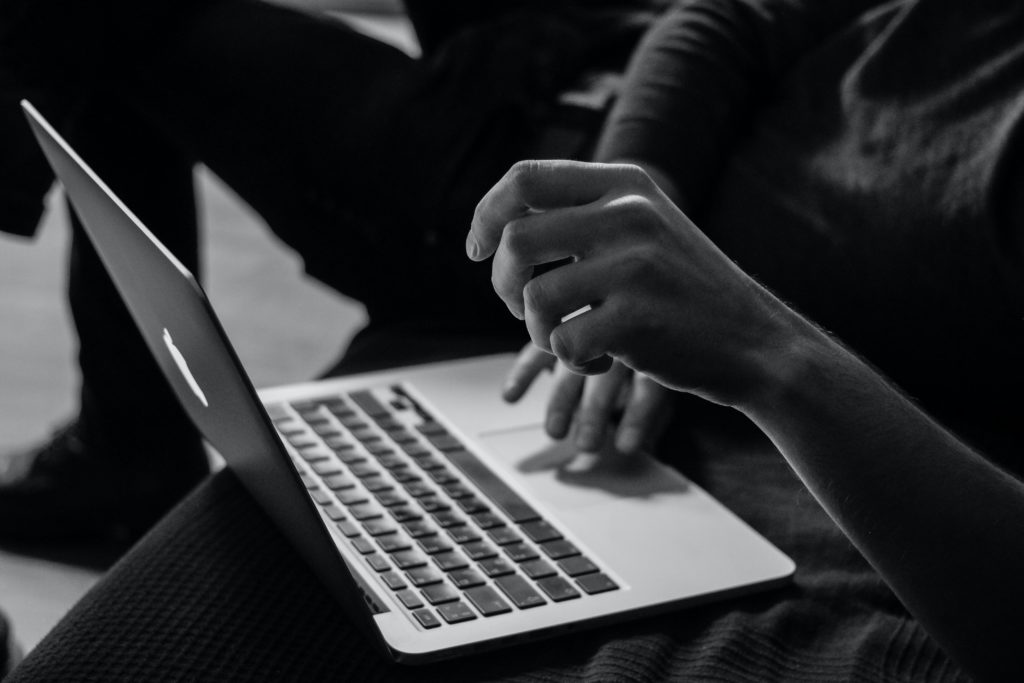 Black and white image of a person using a laptop